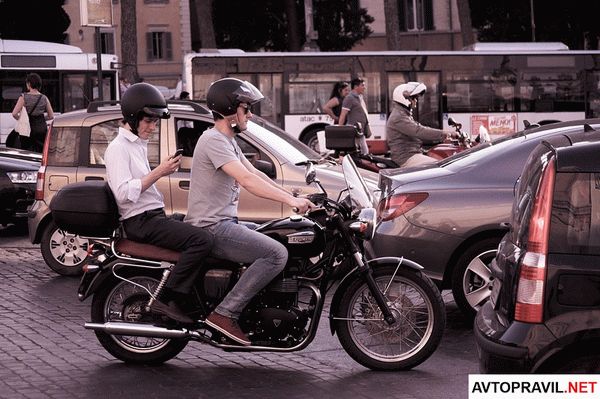 Двое мужчин, которые едут на мотоцикле